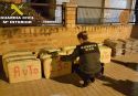 Un agente de la Guardia Civil, inspeccionando los paquetes de droga incautada en la operación