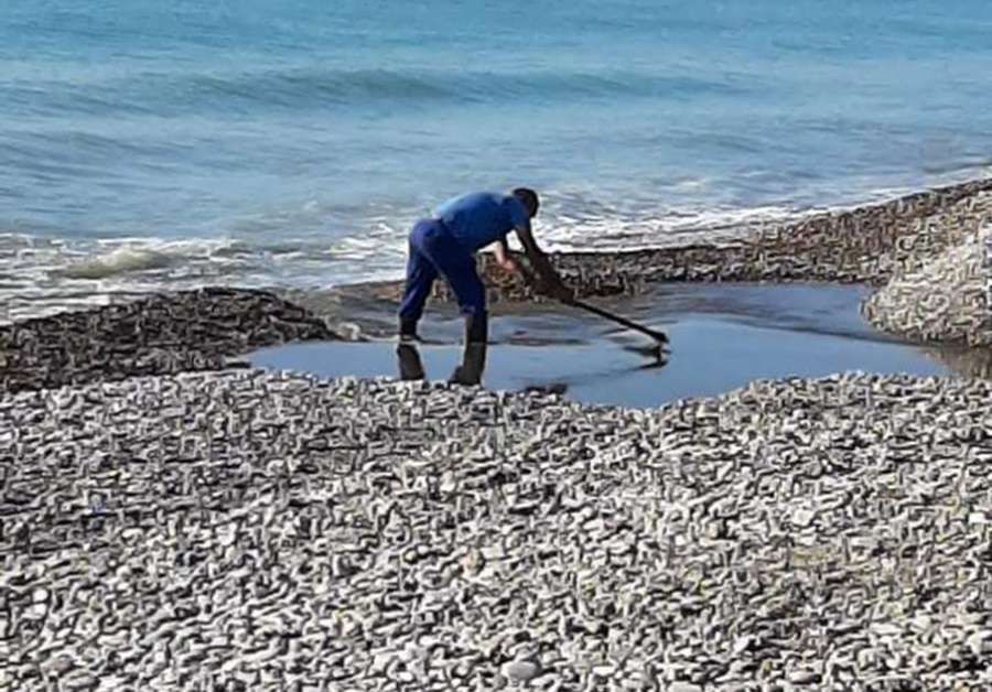 Un operario elimina la barrera que impide desaguar a la gola en las playas de Almardà.