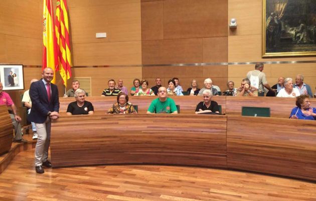El alcalde de Faura de pie y los mayores sentados en los escaños de la Diputación