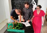 El artista fallero, Paco Giner, firmando el contrato junto a los representantes de El Palleter