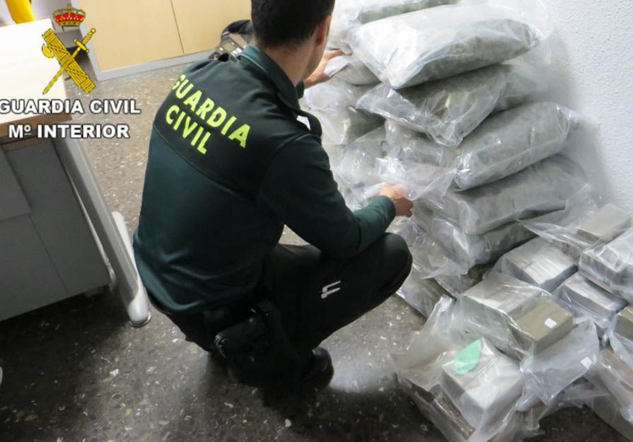 Un agente de la Guardia Civil inspecciona las drogas incautadas