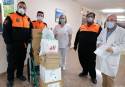 Voluntarios de Protección Civil entregando mascarillas al personal del Hospital de Sagunto